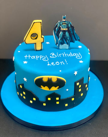 Batman-themed birthday cake with number 4 on a blue background.