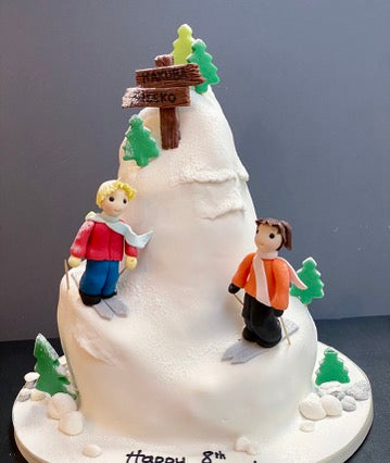 Mountain Shaped Cake with two figures skiing down it