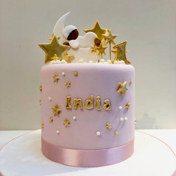 Tall cake with sleeping baby on a moon and lots of stars