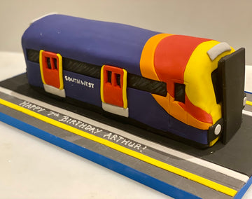 Train-shaped birthday cake with 'Southwest' branding on a platform