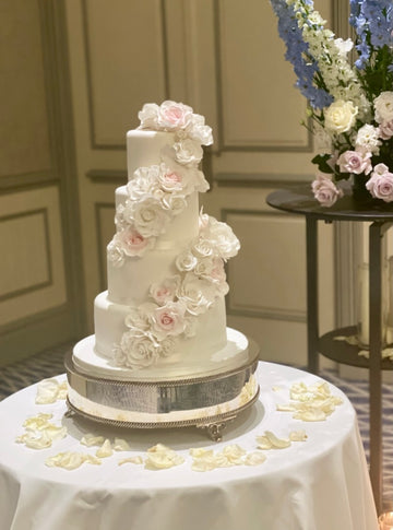 White 4 Tiered Wedding Cake with a sugar flowers swathe wrapped around it