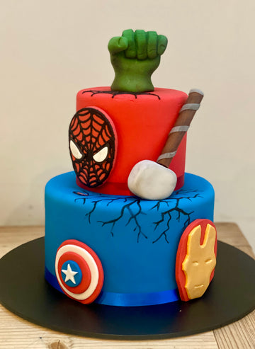 two tiered birthday cake with hulk topper, spiderman, thor's hammer and iron man and captain america