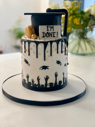 Tall Graduation Hat with Silhouettes of people Throwing Hats in the and a mortar board hat on top