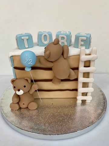 Half a cake decorated with teddies and a ladder