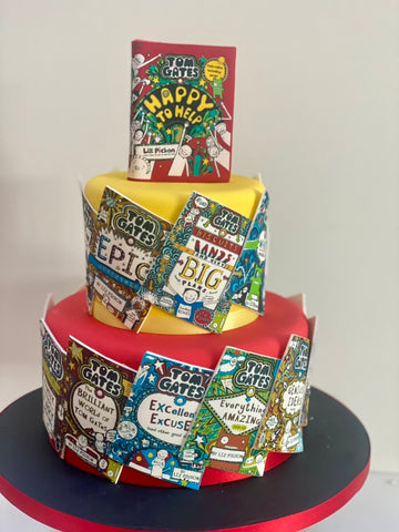 Three-tiered cake decorated with Tom Gates book covers on a white background