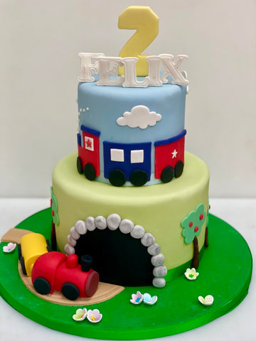 Two-tier birthday cake with train design and '2' on top