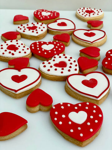 Heart-shaped cookies decorated with red and white icing for Valentine Day