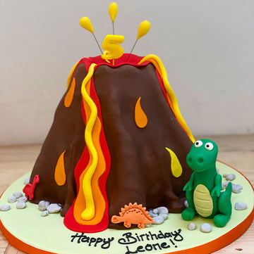 Volcano shaped birthday cake with dinosaur figures
