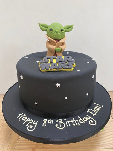 Birthday cake decorated with yoda and the star wars logo