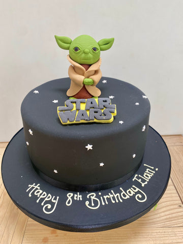Black star wars cake with yoda figure on top