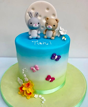 Ombre garden birthday cake with a sugar bunny and teddy bear on top