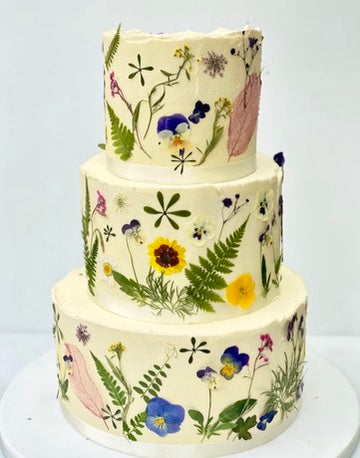 three tiered buttercream wedding cake with dried flowers decoration