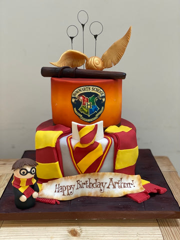 Harry potter birthday cake decorated to look like the Hogwarts uniform with Harry as a sugar figure