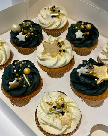 Decorative cupcakes with black, gold, and white icing and stars
