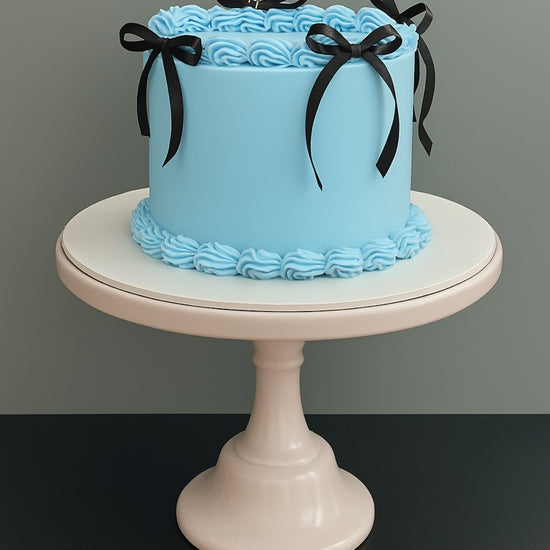 Blue baby shower and birthday cake with ribbons