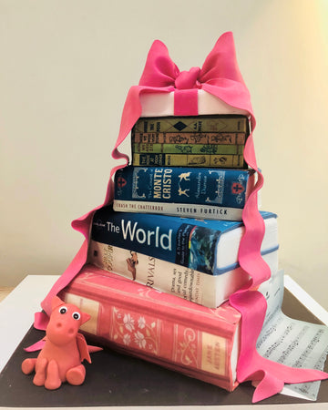 Cake to look like a stack of books with a big pink bow on top