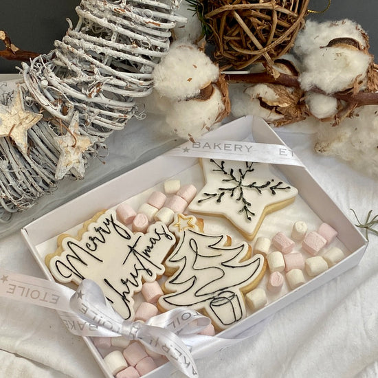3 monochrome christmas cookies in a beautiful box, with tiny marshmallows around all tied with a ribbon. Available to be posted across the UK