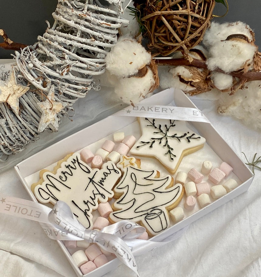 3 monochrome christmas cookies in a beautiful box, with tiny marshmallows around all tied with a ribbon. Available to be posted across the UK