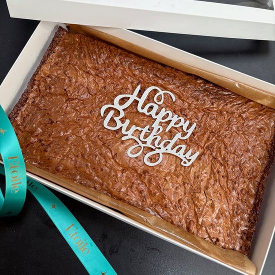 Brownies in a box with 'Happy Birthday' text on a black background