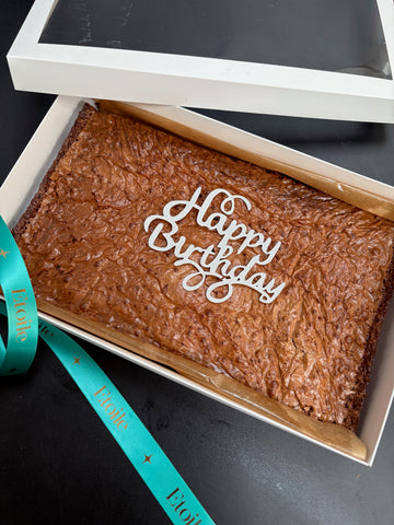 Brownies in a box with 'Happy Birthday' text on a black background
