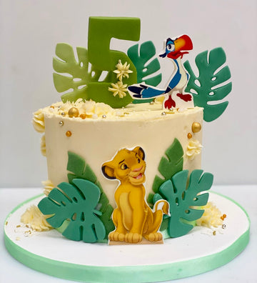 Buttercream Lion King Birthday Cake with Simba and Zazu and jungle style leaves