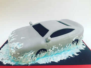 3D car carved from cake splashing through a puddle