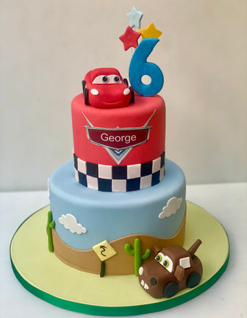 2 tier birthday cake decorated to the theme of cars the movie, with two car figures from sugar