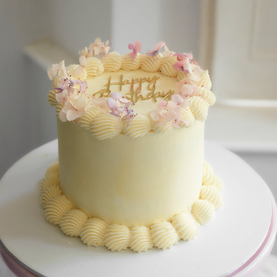 piped buttercream cake with dried hydrangeas on top to decorate