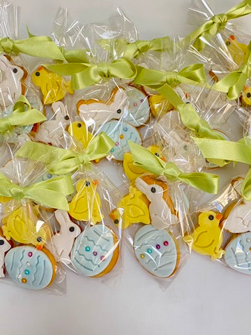 Easter cookies shaped like eggs, rabbits and chicks all wrapped in cello bags for gifts