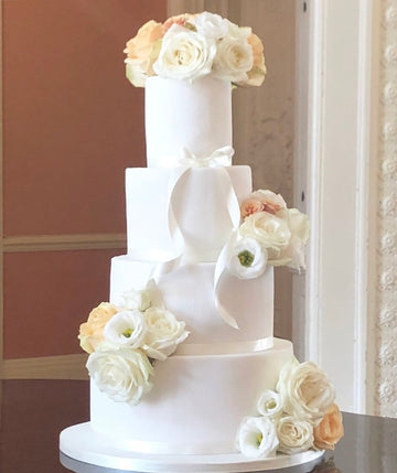 Elegant white fondant cake with peach and cream fresh flowers delivered london
