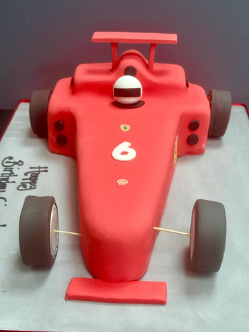 Birthday cake carved to the shape of a formula 1 racing car