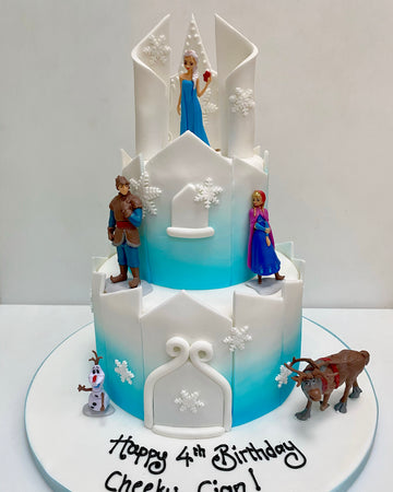 Birthday cake decorated to look like a castle with the characters from frozen