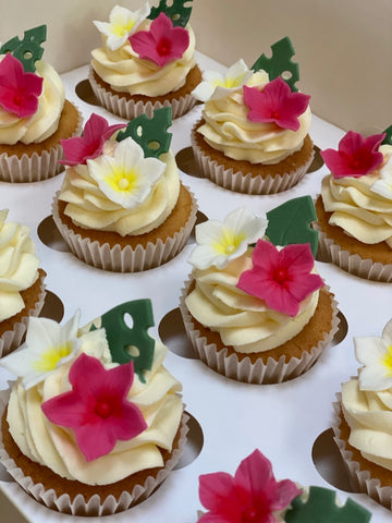 Cupcakes decorated with fuchsia and white tropical flowers 
