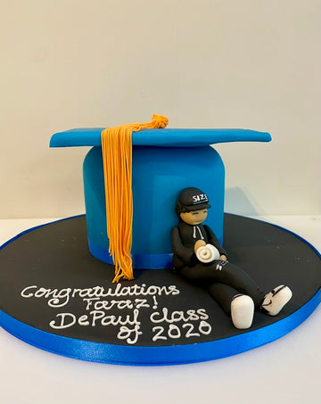 Graduation-themed cake with a blue cap, yellow tassel, and a figurine of a police officer on a black base.