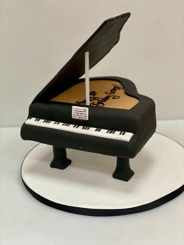 Cake designed to look like a grand piano on a white background