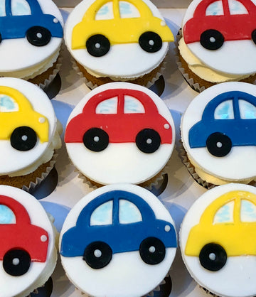 Cupcakes decorated with colorful car designs on a white background