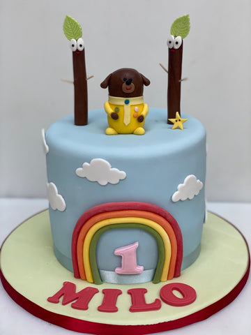 Hey Duggee Birthday Cake Delivered london with duggee on top and a rainbow at the front and the trees with eyes