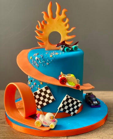 Hot Wheels themed birthday cake iwth cars and flames and a race track around the cake
