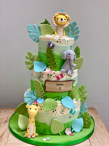 3 tiered birthday cake decorated with sugar animals in a jungle theme