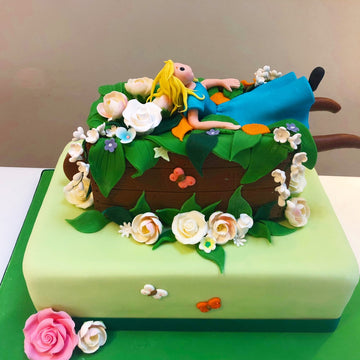Gardening Themed Cake with a lady in a wheel barrow surrounded by flowers