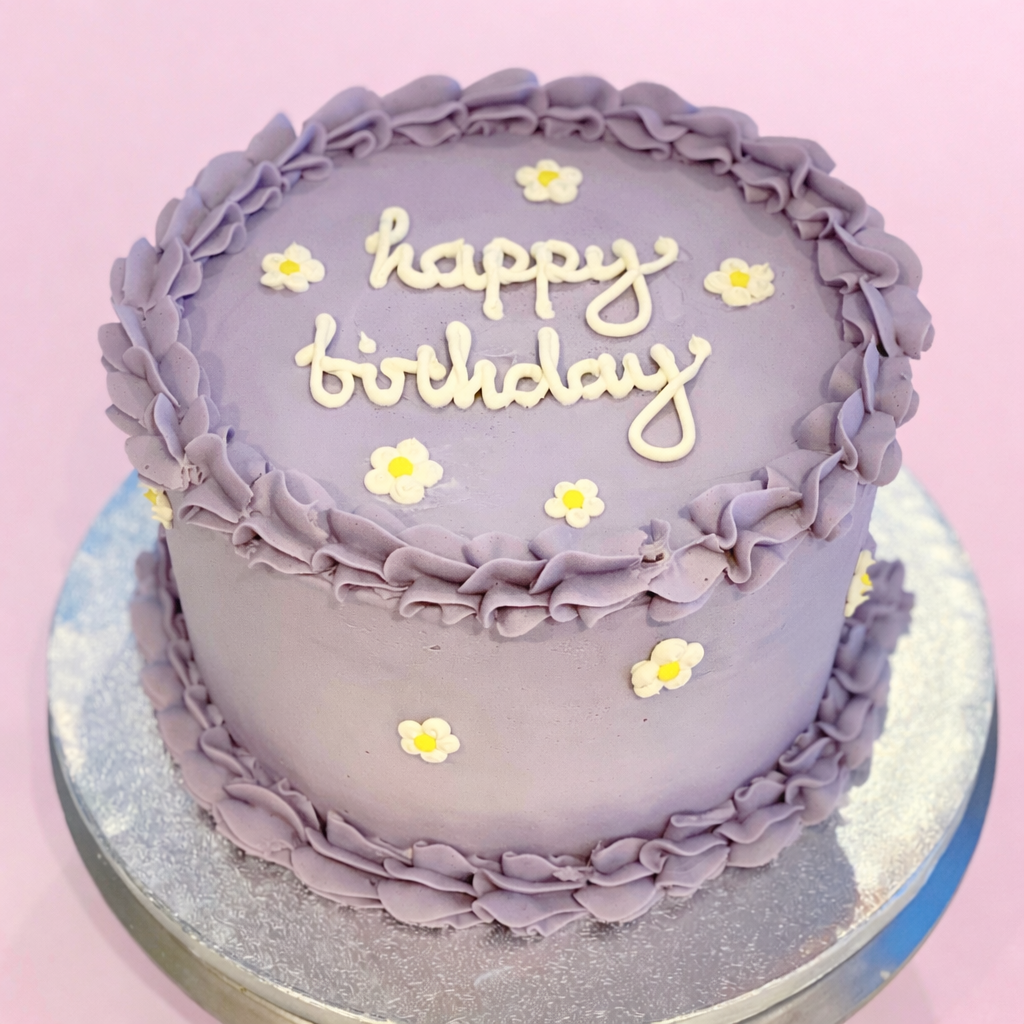 Lilac buttercream birthday cake with pretty iced daisies delivered in london
