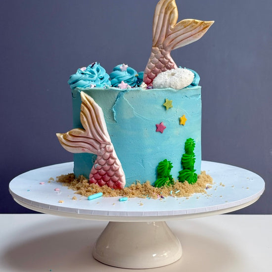 Mermaid-themed Buttercream birthday cake with mermaid tails and ocean decorations ready to order in london