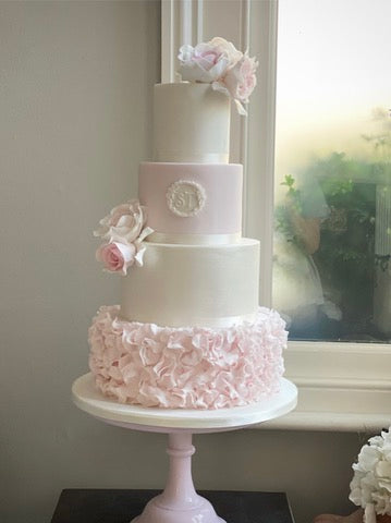 Pale Pink and White 4 Tiered Wedding Cake with a pale pink ruffle, monogram and pink sugar roses