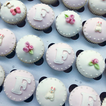 Pretty pink and white cupcakes with an initial, roses, butterflies and bunnies