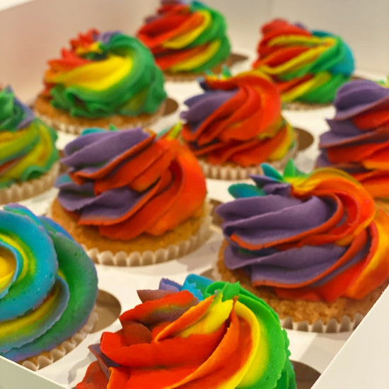 Colorful rainbow cupcakes in a box