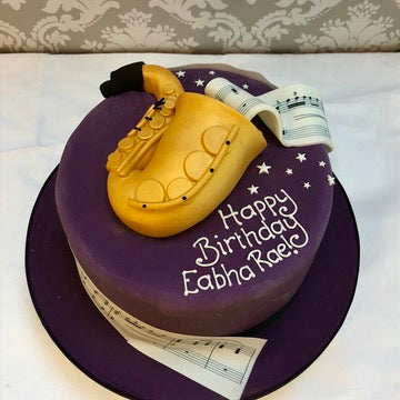 Birthday cake with a sugar saxophone on top and musical notes