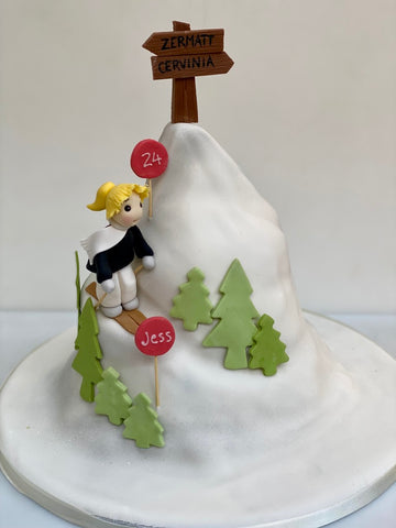 cake carved to look like a mountain with a skier coming down