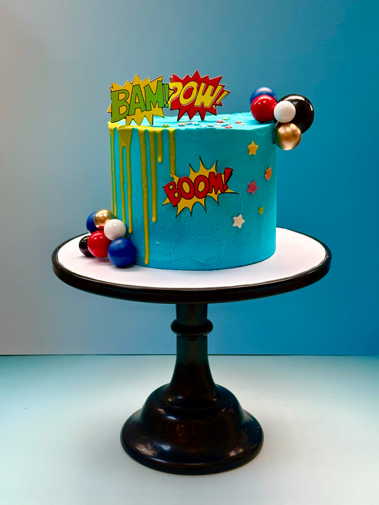 super hero birthday cake delivered in london with comic themed exclamation speech bubbles to decorate