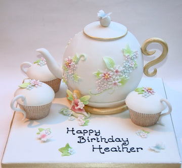 Cake shaped like a teapot and cupcakes to look like teacups