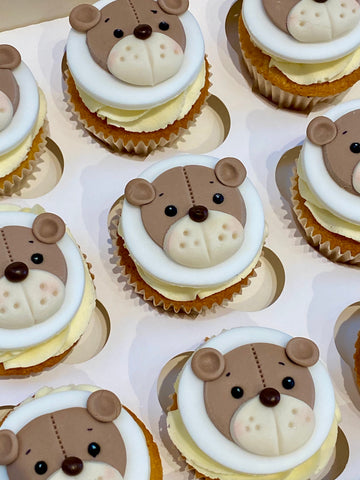 Cupcakes decorated with teddy bear faces on a white tray